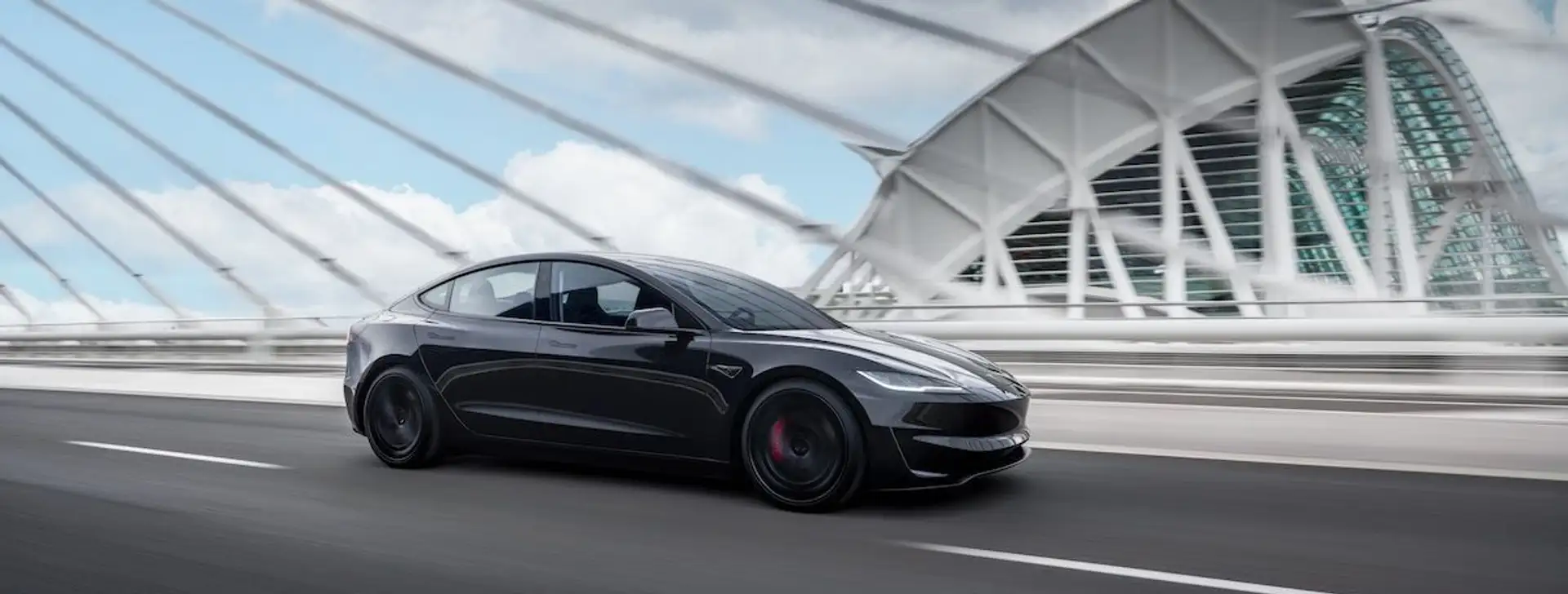 A black Tesla Model 3 Performance on a bridge.